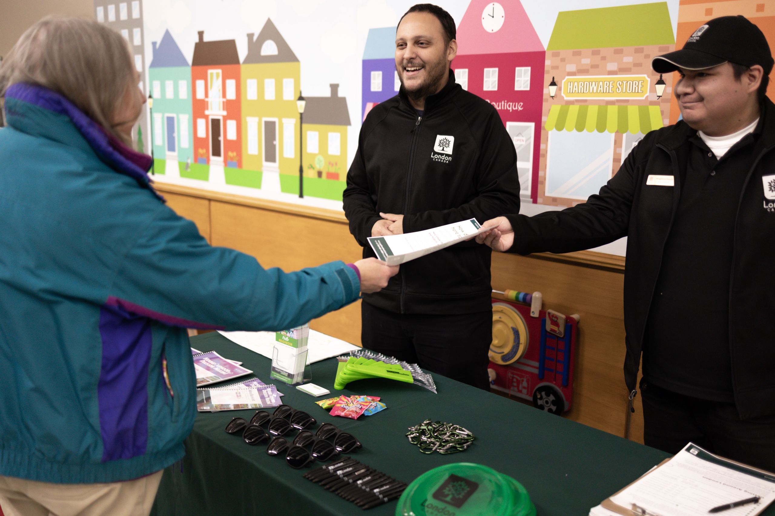 Image of two City of London employees talking with a resident of London.
