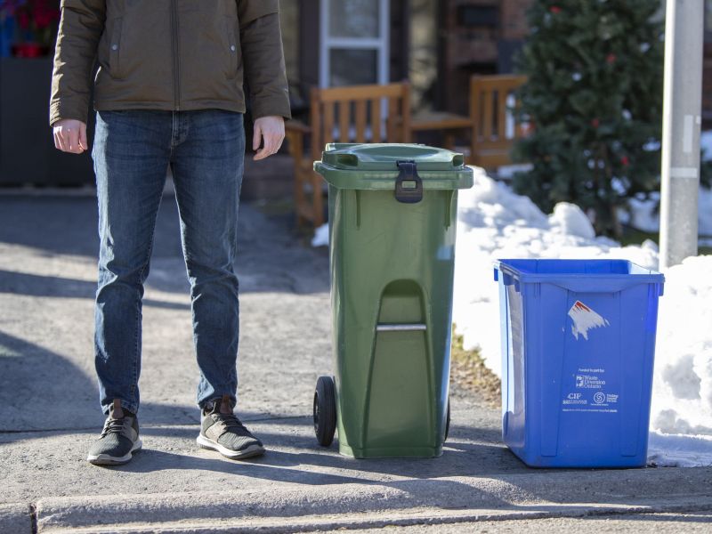 A medium size Green Bin placed at the curb